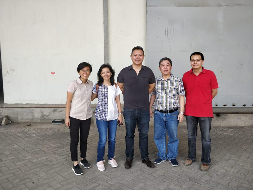 Buyer and factory team outside a production facility