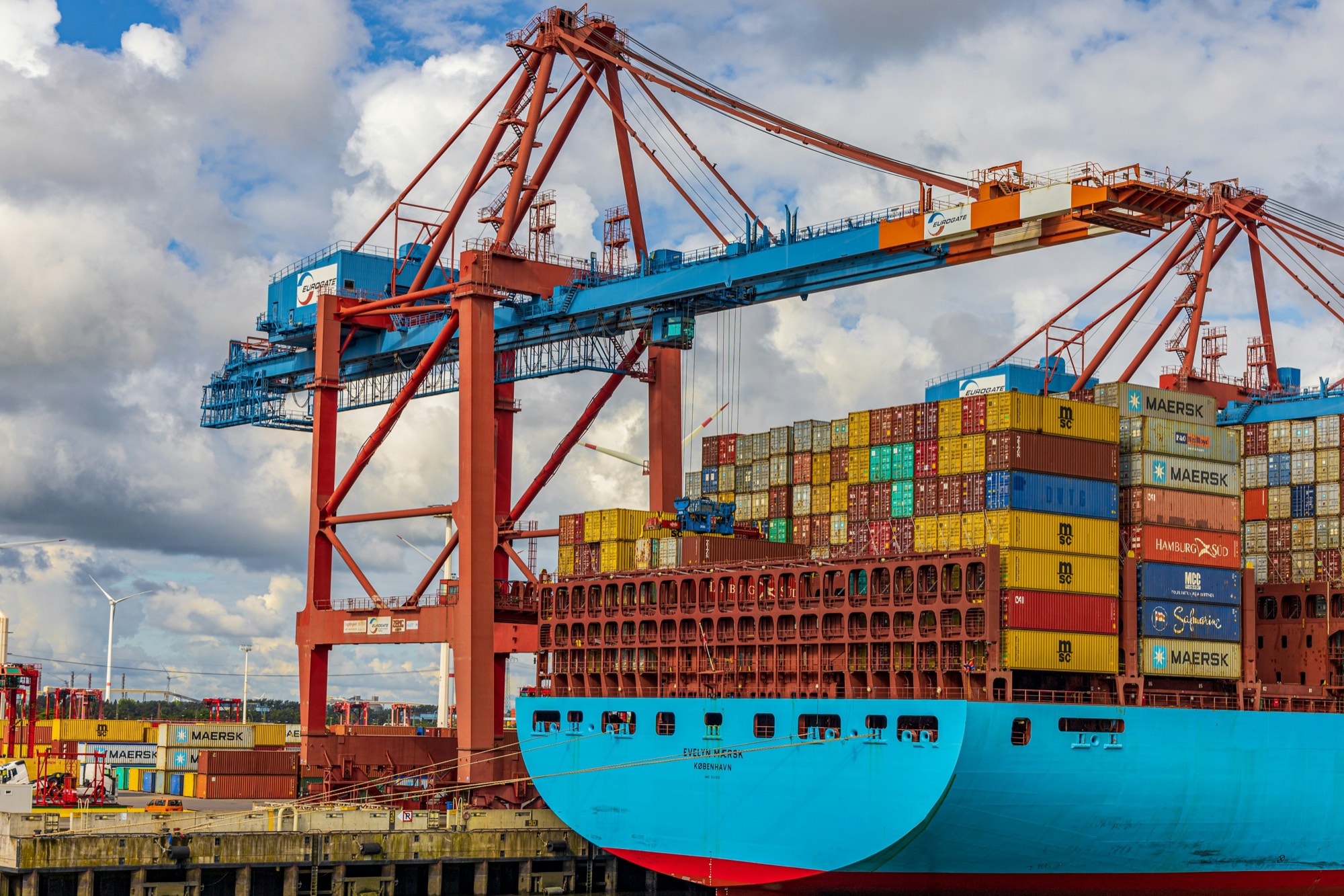 Container ship loaded at a port with cranes overhead