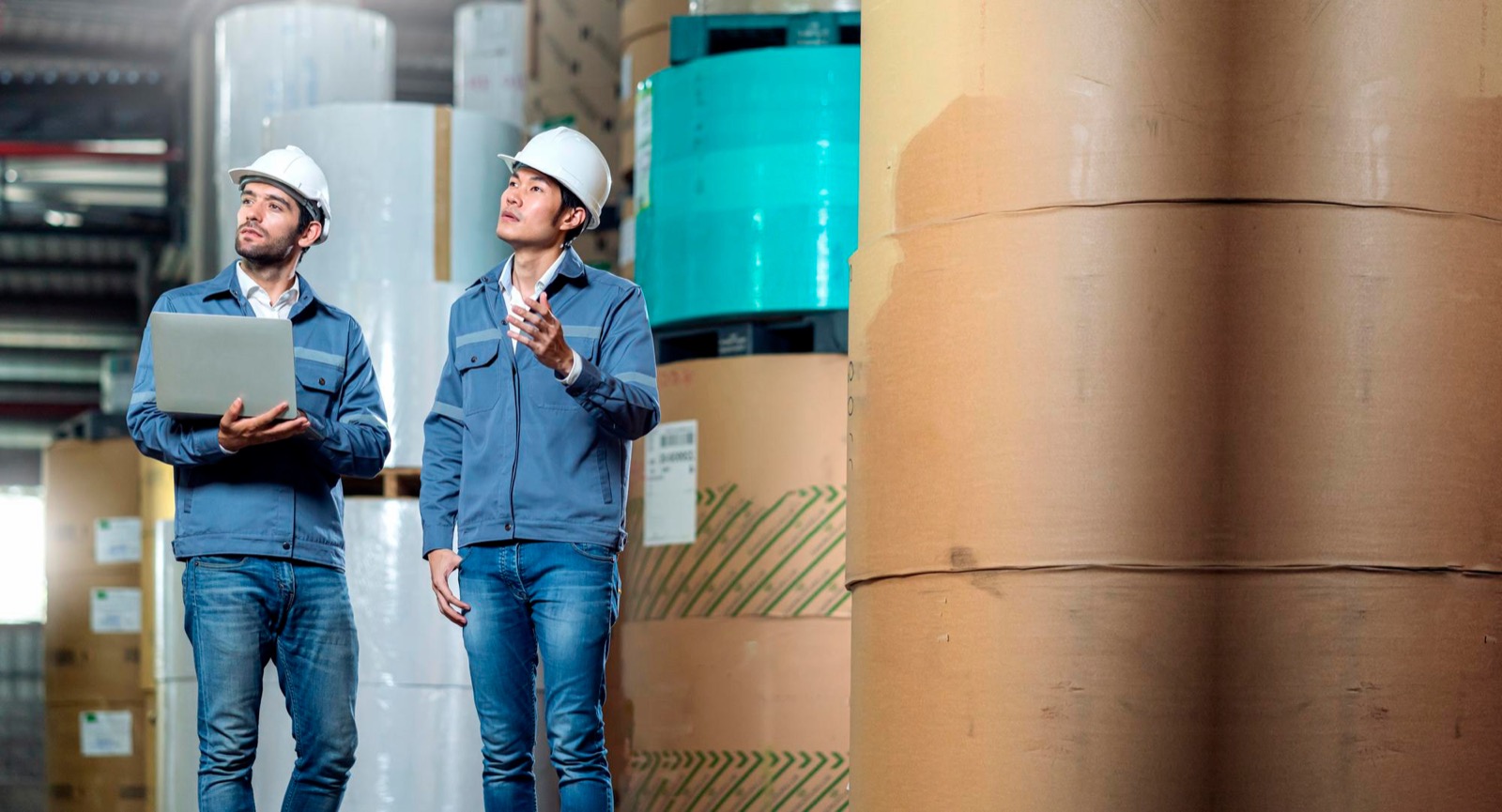 Two inspectors in hard hats reviewing a production floor